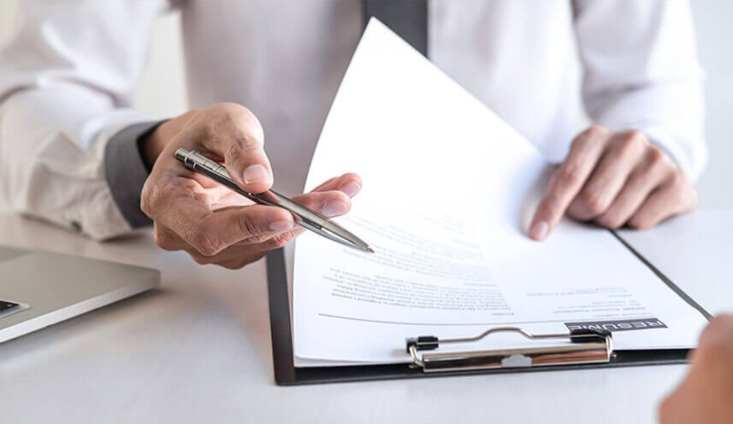 Hands holding pen and clipboard