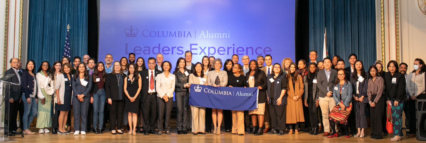 Columbia Alumni leaders holding a "Columbia Alumni" banner.