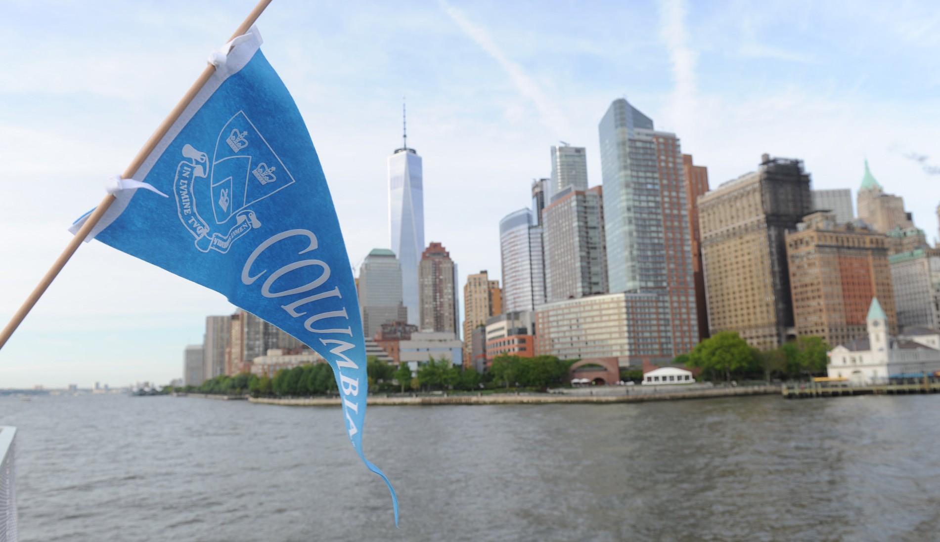 Image of Ellis Island with a blue Columbia University banner with the Columbia Crest in White.