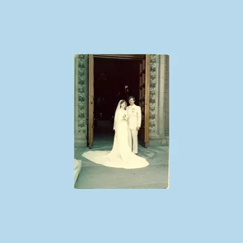 Faded photograph of a bride and groom in a church doorway.