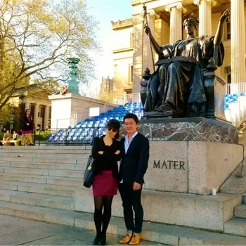 Couple dressed in business casual in front of Alma Mater statue.