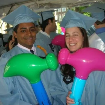 Male and female couple in Columbia regalia and holding inflatable hammers.