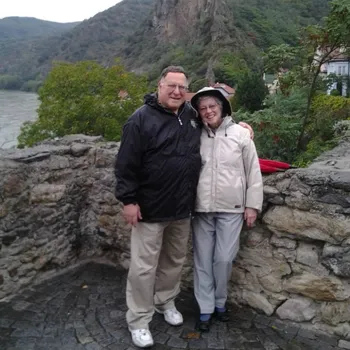 Older couple joyfully smiling in a beautiful natural landscape.