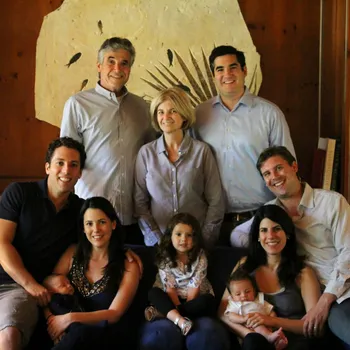 Extended family portrait with parents, adult children and baby and toddler grandchildren. 