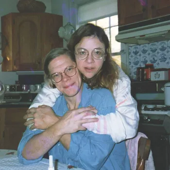 Couple embracing in a kitchen setting.