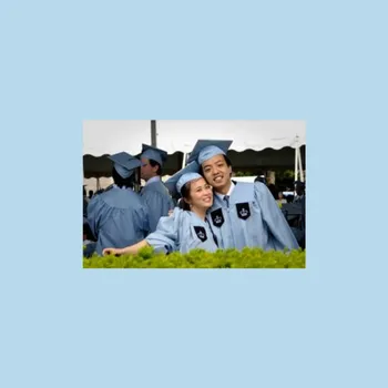 Male and female couple on campus in Columbia cap and gown.