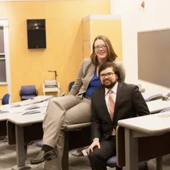 Male and female couple sitting in a classroom.