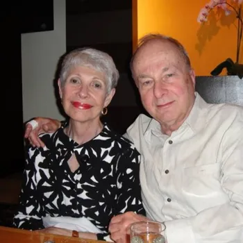Older couple at a relaxing dinner gently smiling together.