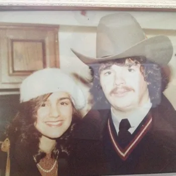 Young female and male in western cowboy had both dressed up and smiling in polaroid.