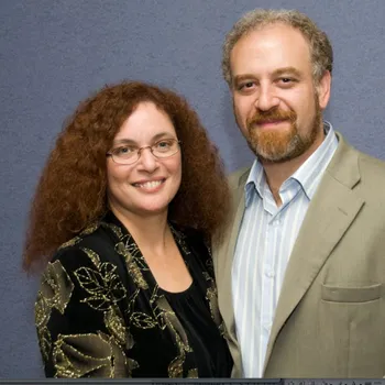 Male and female couple standing close.