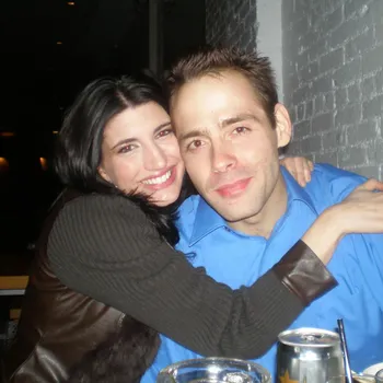 Male and female couple embracing at a restaurant table.