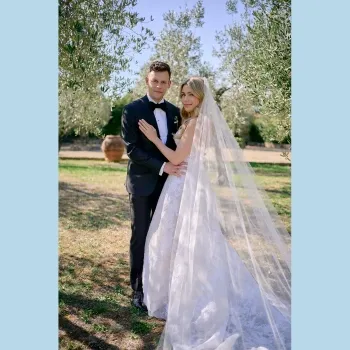 Bride and groom standing in an open field.