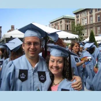 Man and woman at commencement  on Morningside Campus in caps and gowns.