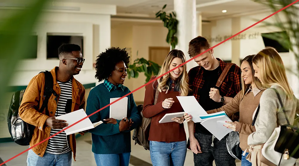Stock image of students in a hallway, looking at papers.