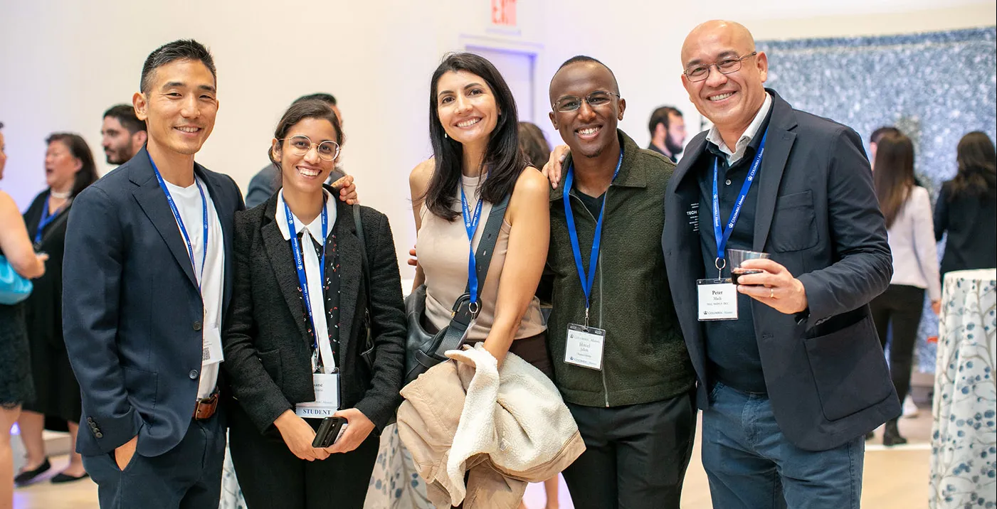 Group of people wearing name badges smiling together at a networking event.