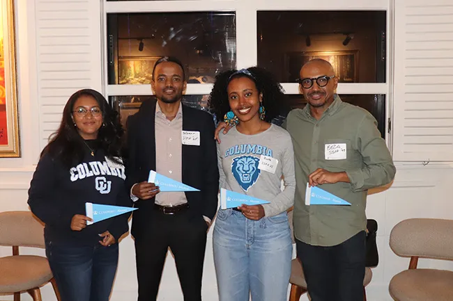 Columbia University students and alumni holding Columbia pennants. 