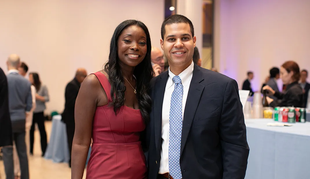 Nicole Bullock and Carlos Cuevas, dressed formally, smiling together at the Leaders Experience conference.