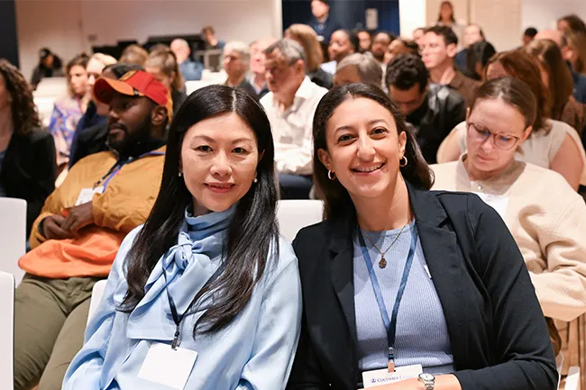 Anita Ma and Maryam Hassan sitting in a panel audience.